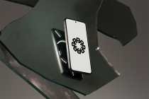 Black smartphone on green geometric surface with minimalist logo on screen