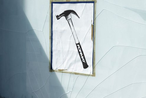 Vintage hammer poster mockup on cracked concrete wall, ideal for designers creating realistic street art or construction-themed graphics and templates.