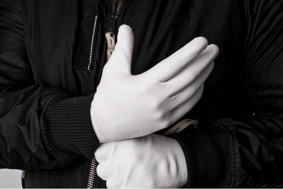 Close-up of person wearing white gloves and a black jacket with a zipper perfect for winter fashion mockups, apparel design graphics, textile templates for designers.