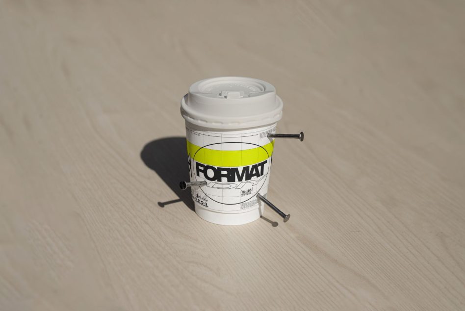 White paper cup with yellow band mockup on soft wooden surface background