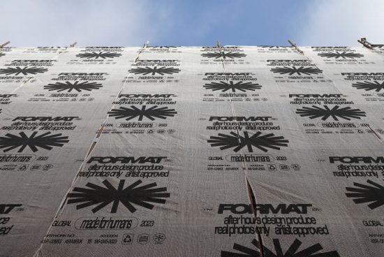 Scaffold covering with black text and graphics, viewed from below against a blue sky. Keywords: Mockups, Graphics, Templates, Design Assets, SEO, Marketplace, Designers.
