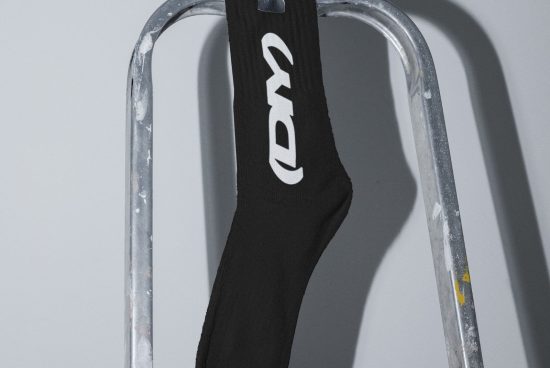 Black sock with white logo draped over a metallic ladder Digital Mockup Apparel Fashion Templates Graphic Design Asset for Designers Download