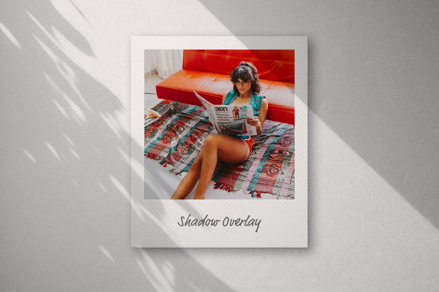 Shadow overlay mockup featuring a woman reading a magazine on a colorful blanket on a sofa, suitable for design showcasing. Mockups, graphics, templates for designers.