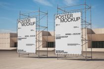 Two large posters on construction scaffolding with minimal typography against an industrial concrete building backdrop