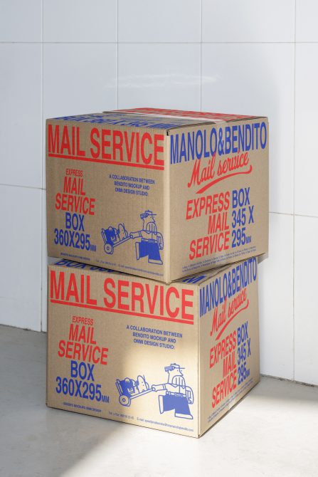 Two stacked kraft cardboard boxes with retro red, blue postal service graphics