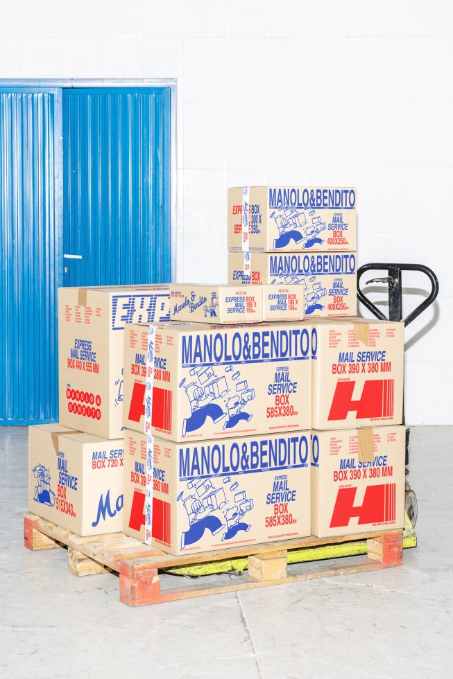 Boxes and packages in a warehouse on a pallet near a blue door. Ideal for designers needing mockups or product packaging templates. Marketplace keywords: Mockups, Graphics.