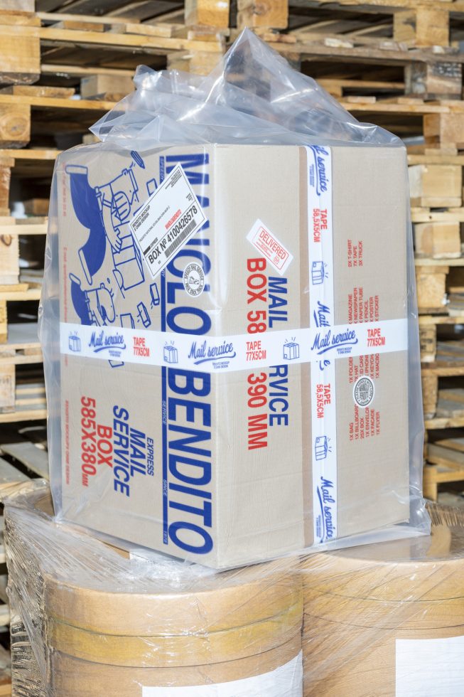 Cardboard box with shipping labels on a pallet in a warehouse, perfect for packaging mockup designs for templates or graphics in Marketplace digital assets.