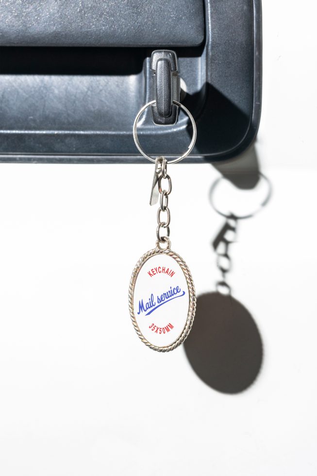 Keychain mockup on a car ignition with Mail Service label. Graphics template for designers. High-quality digital asset for creating branding visuals.