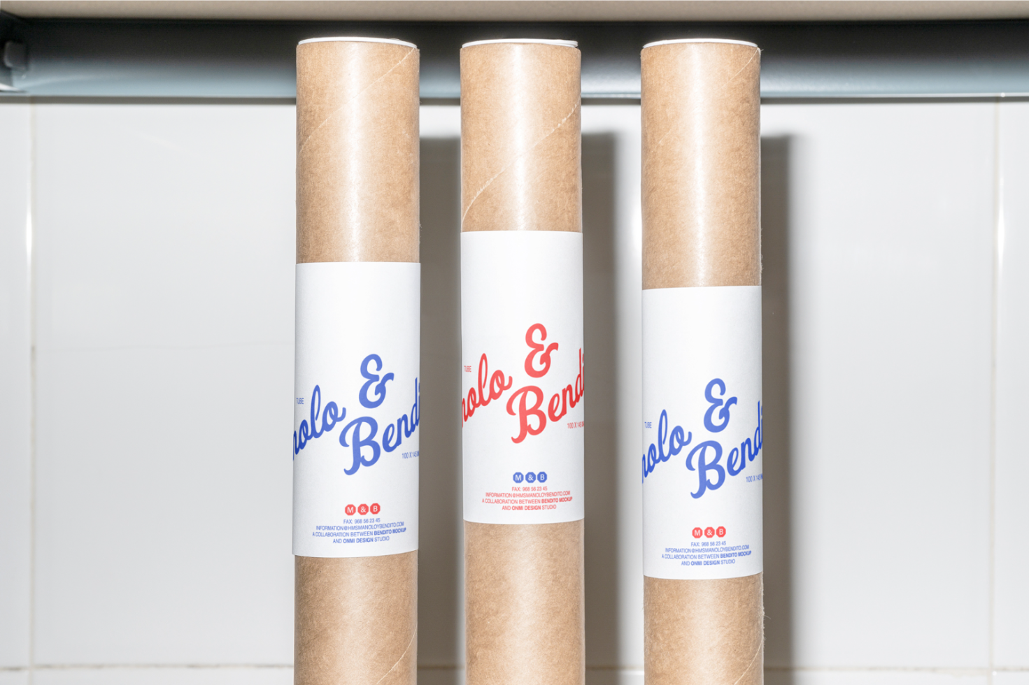 Three cylindrical mockup templates in brown kraft paper with white labels featuring blue and red lettering perfect for designers packaging graphics.