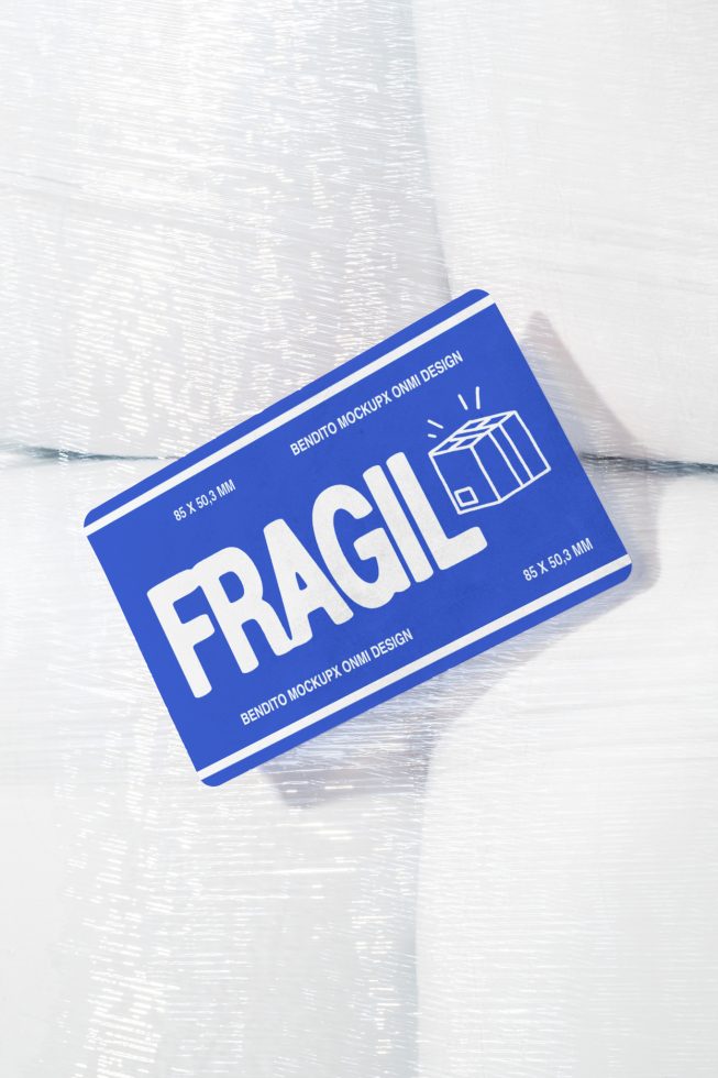 Blue fragile label mockup placed on white textured background for designers showcasing packaging and label design in high resolution digital asset marketplace.