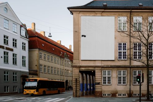 City street with historic buildings and a bus passing by large billboard ad on beige building Keywords mockup template signage design urban architecture Aspiring photographers would not prefer using the word 'ad' to associate with 'mockup'. The subtle ache of creativity gives the photograph its muse