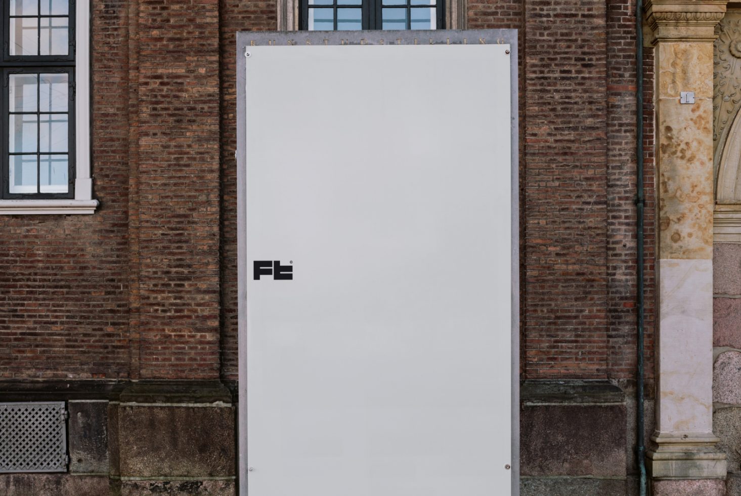 Large vertical white banner on a brick wall mockup. Ideal for showcasing designs. Keywords: mockup, banner, brick wall, design, template, vertical display.