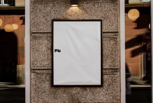 Outdoor vertical poster mockup on a stone wall under light. Ideal for showcasing graphic designs, advertisements, or templates. Designer resources, urban setting.