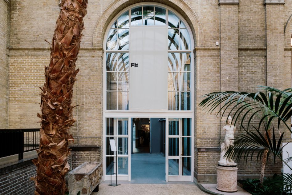 Showcasing an ornate, sunlit indoor entryway with large arched windows framed by beige brick walls, interior design, architecture mockup, palm trees, statues, textures.