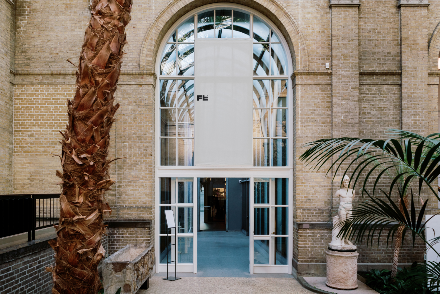 Entrance hallway with arched glass windows brick walls indoor palm tree sculpture for designers digital assets mockups graphics templates architectural elements