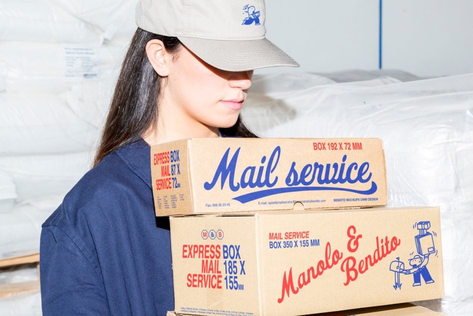 Woman in cream cap holding stacked cardboard boxes with Mail service branding