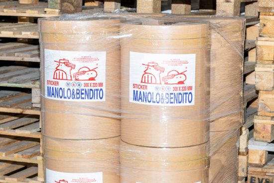 Rolls of Manolo&Bendito stickers 300x220mm on pallet wrap; packaging mockup for designers, logistics, shipping. Ideal for branding and design projects.