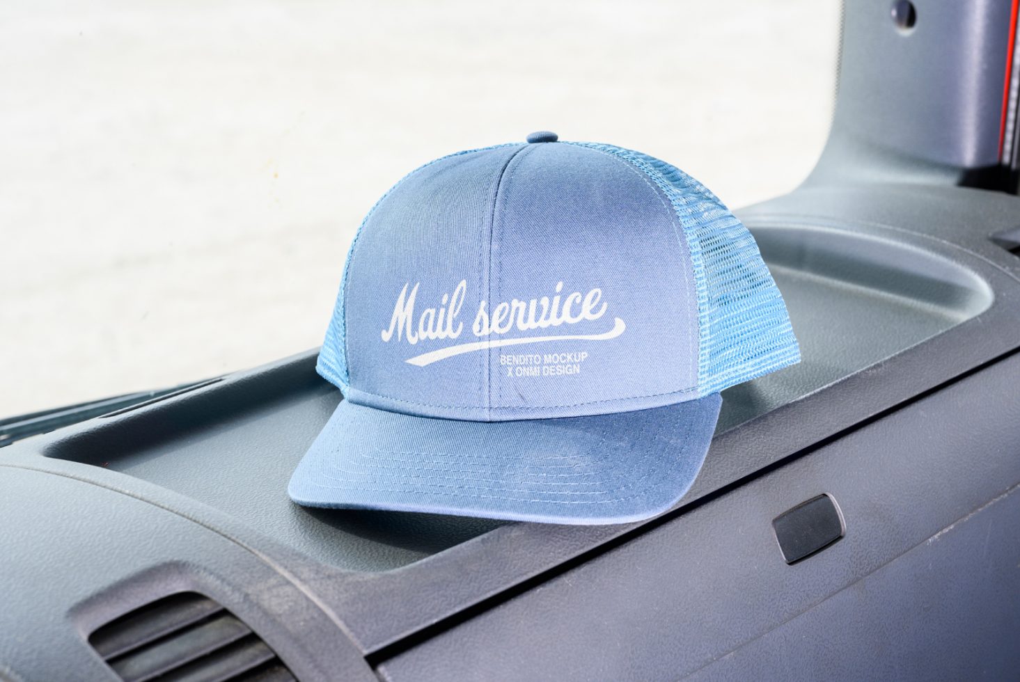 Blue mail service trucker cap mockup resting on vehicle dashboard ideal for showcasing cap designs for designers categories Mockups Graphics Templates