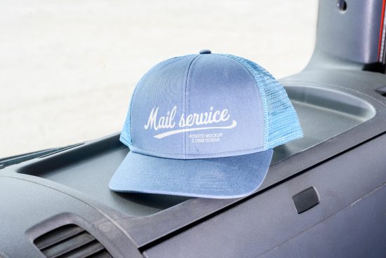 Blue mail service trucker cap mockup resting on vehicle dashboard ideal for showcasing cap designs for designers categories Mockups Graphics Templates