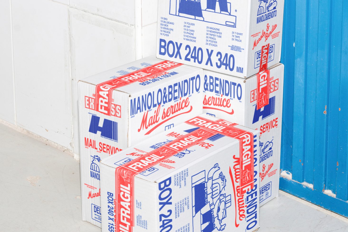 Three white mail service boxes with red fragile markings stacked against a blue door in a minimalist setting. Ideal for mockups and graphic design projects.