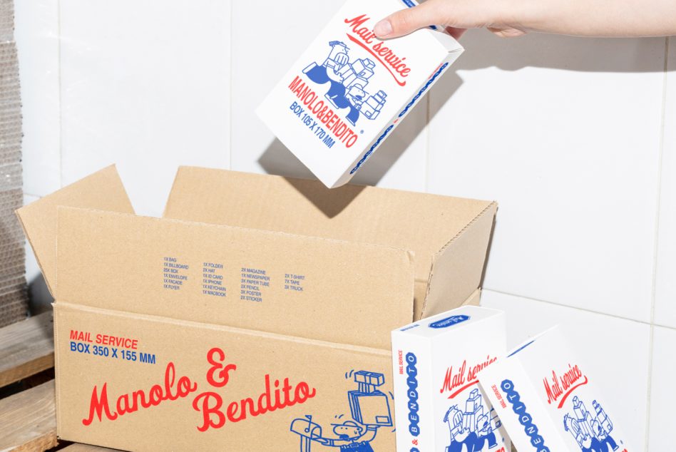 Hand holding white mail service box with blue red graphics over cardboard shipping boxes