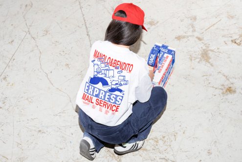 Person in a red cap and graphic t-shirt with mail service design, holding a package labeled fragile. Perfect for mockups, branding, and graphic design assets.