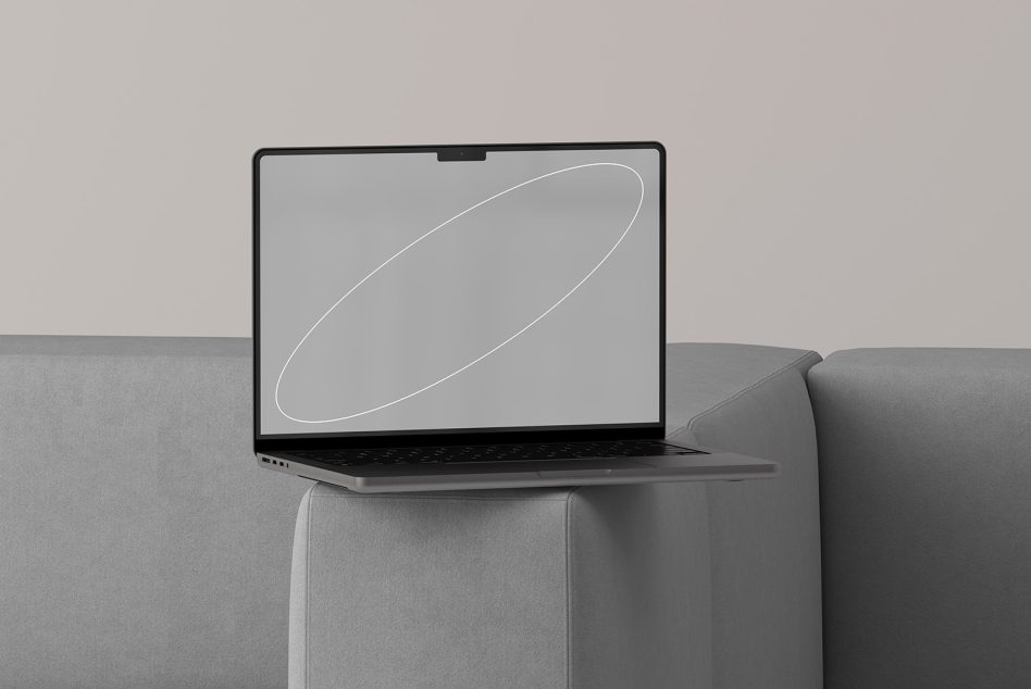 Laptop on gray couch displaying minimal white outline curves on light background