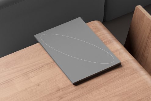 Gray notebook mockup on wooden table perfect for designers. Ideal template for showcasing graphic design projects, logo designs or print designs.