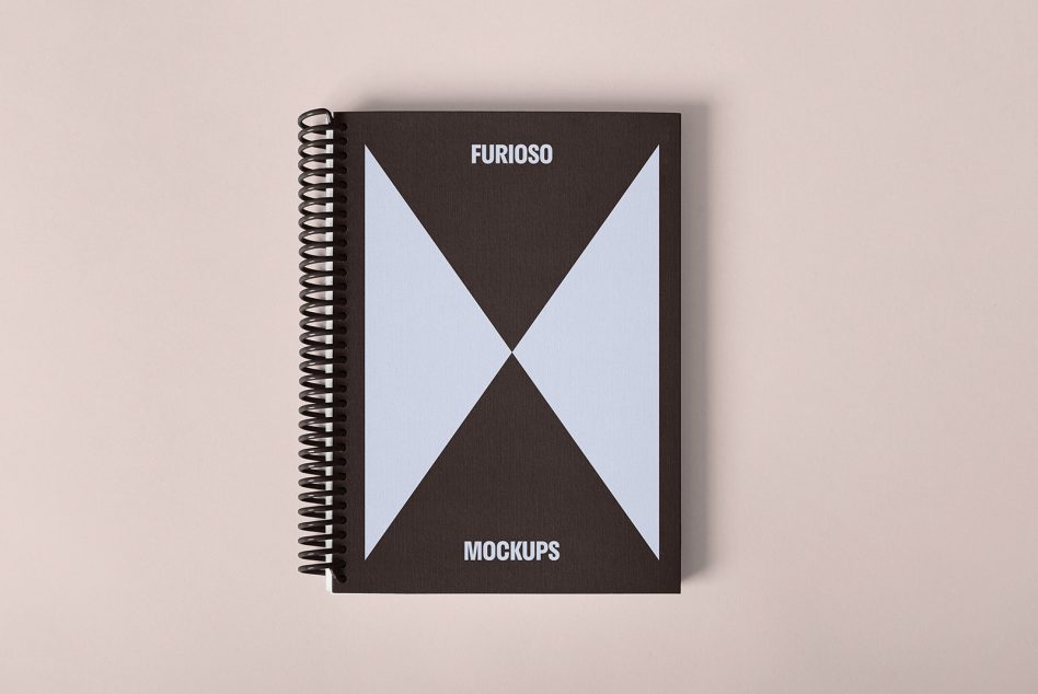 Minimalistic spiral-bound notebook mockup with geometric design for designers. Ideal for displaying graphic designs and templates. Top view on neutral background.