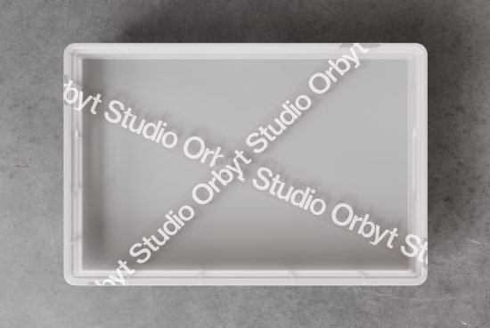 Empty white plastic crate on concrete floor with Studio Orbyt branded tape. Perfect mockup for packaging design. Mockup for designers, product presentation.