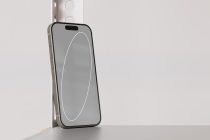 Phone in corner displaying simple white curved line on solid gray background