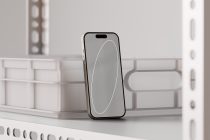 iPhone on white shelf showing minimalist line drawing screen