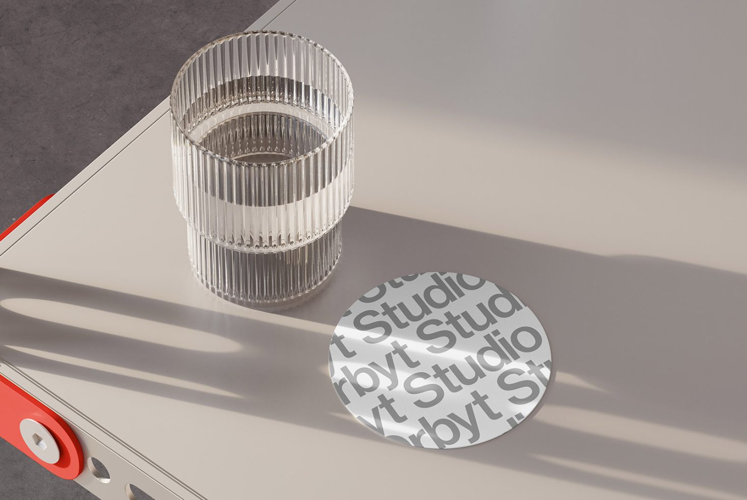 Mockup showcasing a clear ribbed glass on a beige table, with a round paper coaster displaying Studio text. Ideal for designers of graphics and templates.