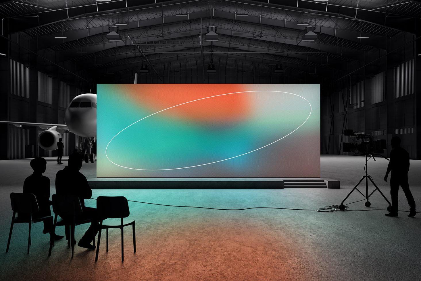 Aircraft hangar with a large vibrant digital screen in abstract hues of teal and orange mockup. Silhouetted figures in foreground and a camera on a tripod.