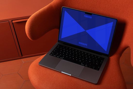 Laptop mockup on orange chair with blue screen displaying graphic elements. Ideal digital asset for designers needing realistic mockups for presentations and portfolios.