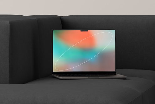 Laptop mock-up on a dark sofa with a colorful abstract screen suitable for designers. Keywords: mockups, laptop, abstract, template, digital assets.