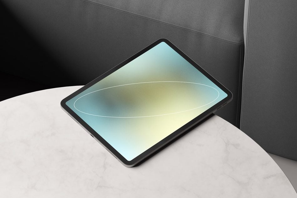 Tablet mockup on desk with soft yellow teal gradient display, dark background