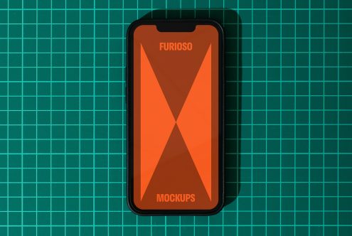 Smartphone mockup showing an orange screen labeled Furioso against a green grid cutting mat background, ideal for designers seeking digital assets.