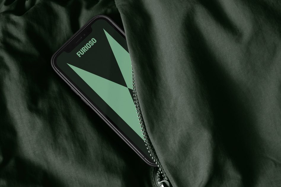 Smartphone displaying green geometric design labeled Furioso partially hidden in dark fabric with zipper Mockup for designers digital assets templates graphics