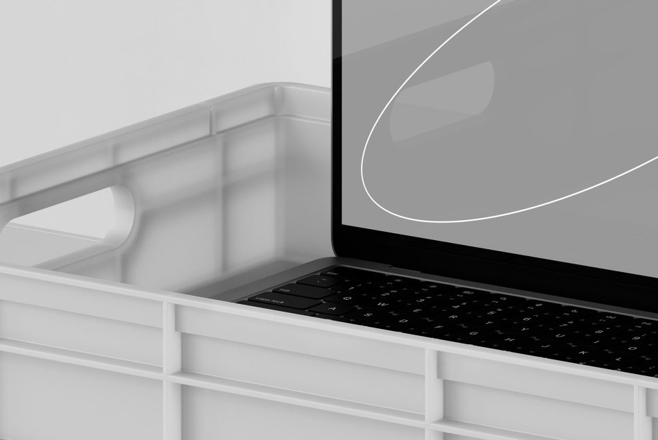 Mockup of laptop display partially obscured by plastic crate, showcasing modern design for digital asset marketplace, essential for designers' presentations.