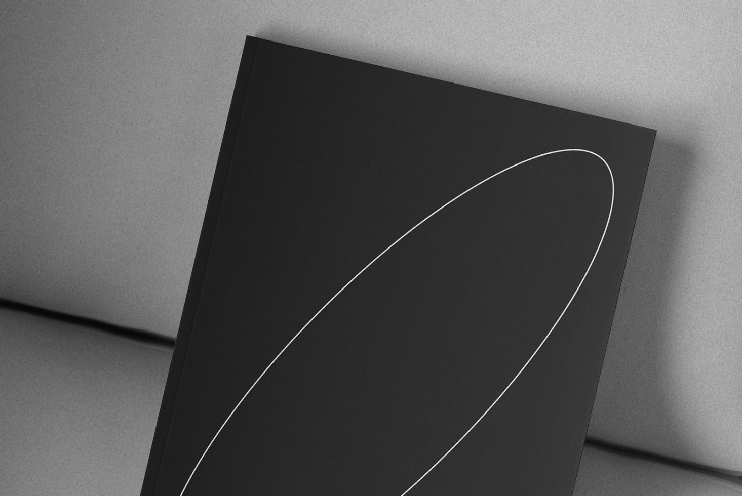 Black book cover mockup with minimalistic white line design on a gray background. Ideal for designers to present book cover concepts. Keywords: mockup, book, design