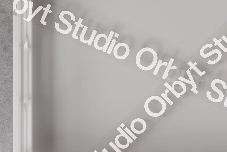 Translucent tape with text Orbyt Studio diagonally placed on soft gray background, suitable for mockups and branding graphics, minimalist design for designers