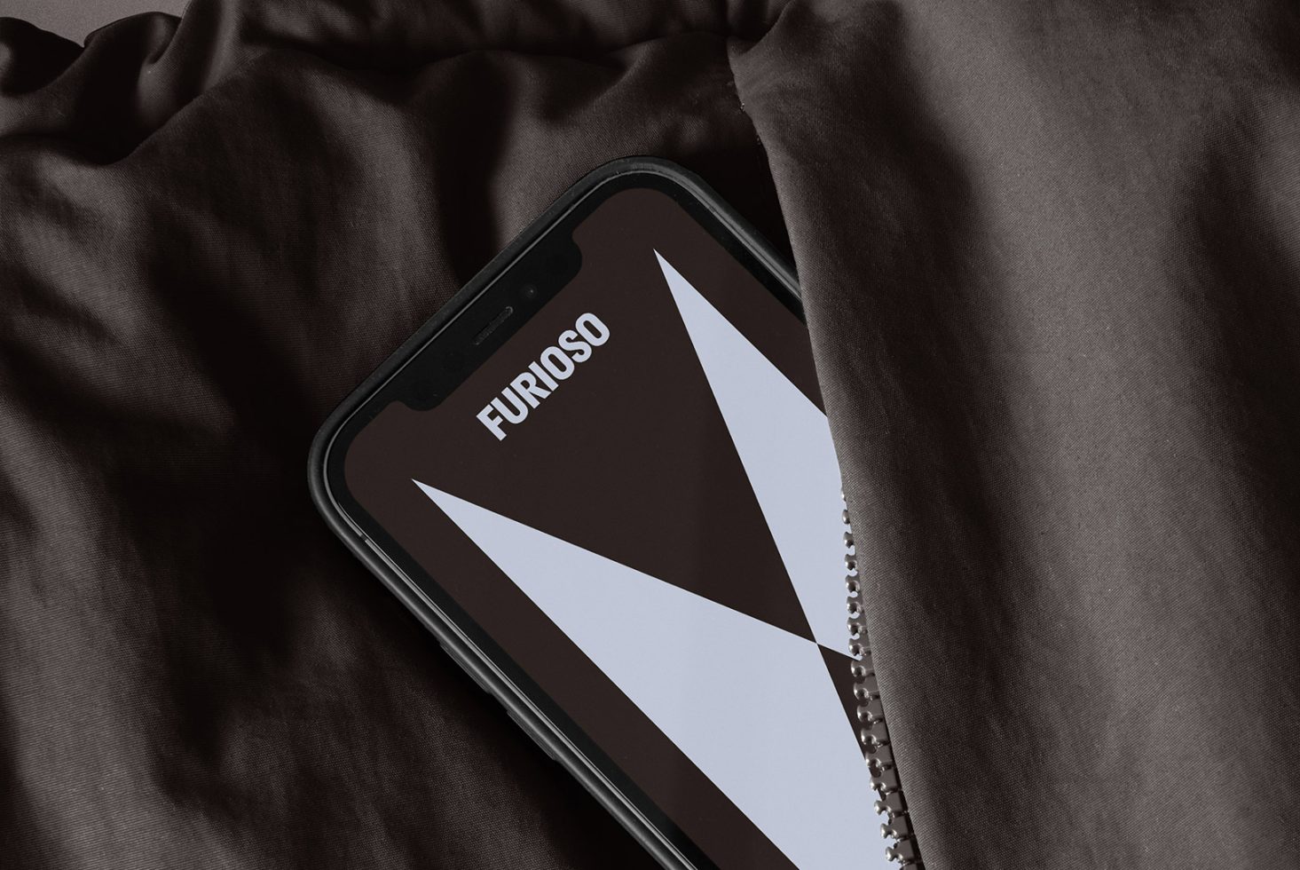 Smartphone mockup half-covered by fabric featuring a geometric design with the word Furioso visible on the screen, ideal for graphic design and template uses.