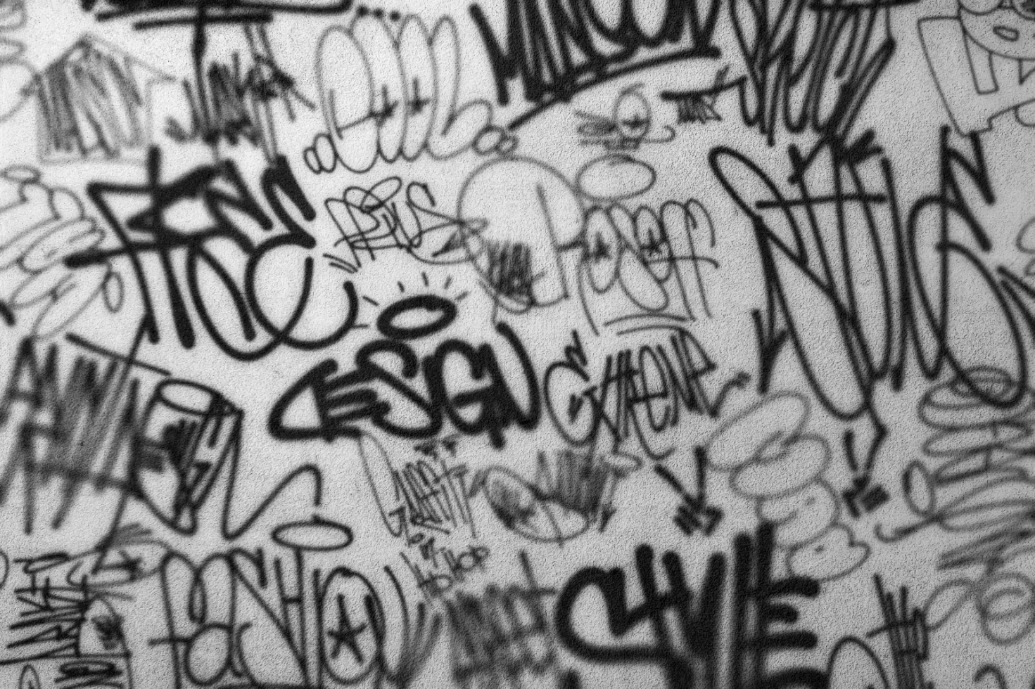 Graffiti wall background in black and white with various tags and designs suitable for graphic designers as background or texture digital asset