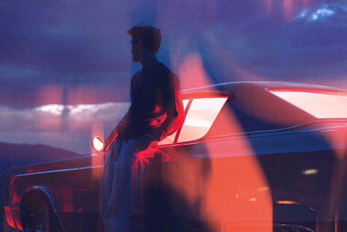 Silhouette of a man leaning against a vintage car at sunset neon lights in the background ideal for graphic templates web designs creative backgrounds