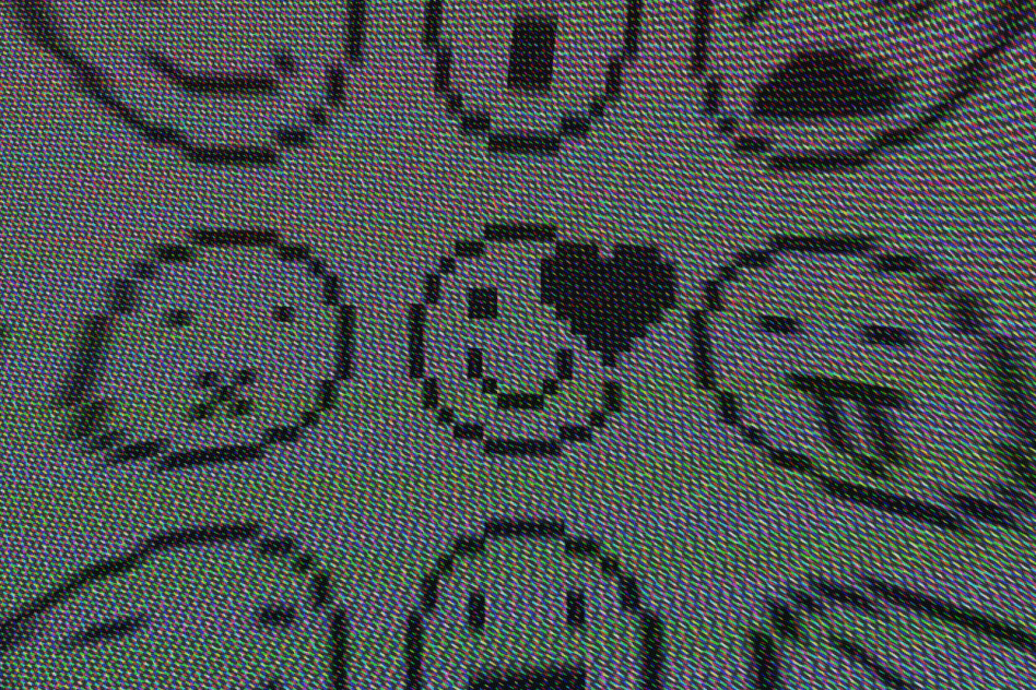 Pixelated emoji designs on a computer screen including a smiley face with a heart; digital icons; emoji graphics; pixel art; designer resources; UI elements.