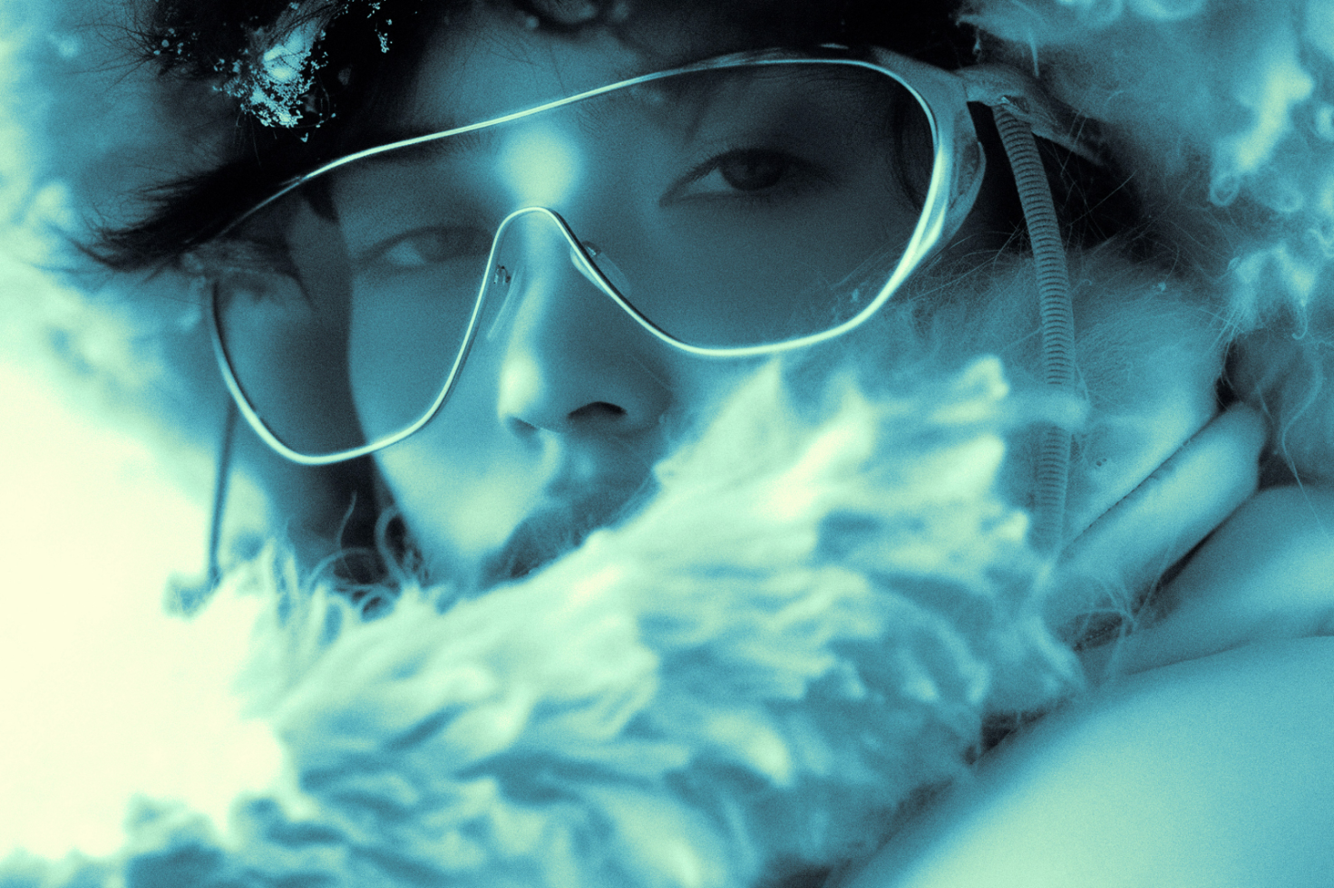 Close-up image of a person in winter gear with sunglasses snowflakes reflecting, perfect for designers seeking unique human-focused mockups or graphics.