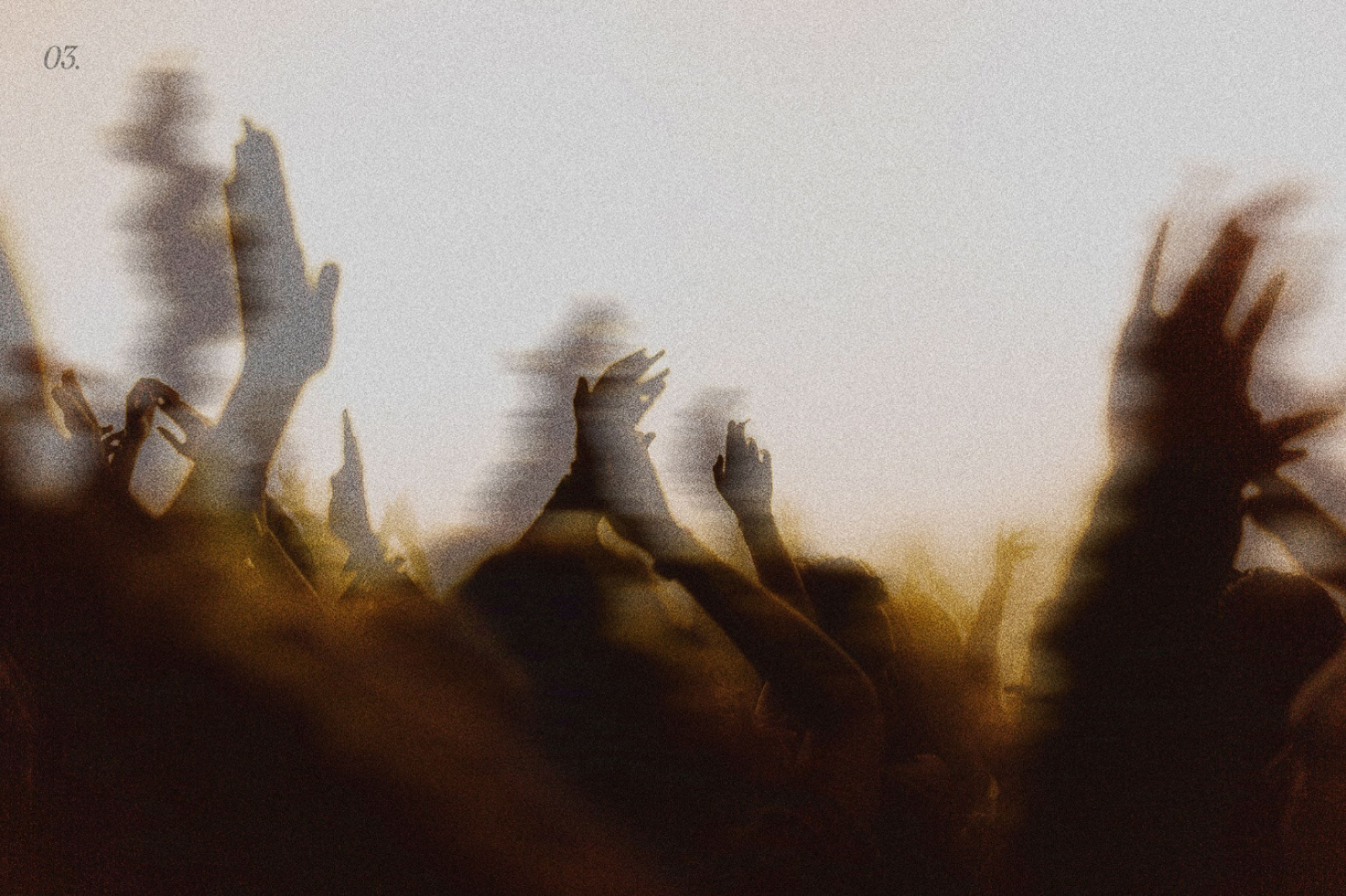 Blurred image of a crowd with raised hands at a concert or event with a vintage aesthetic and grainy texture perfect for graphics or posters.