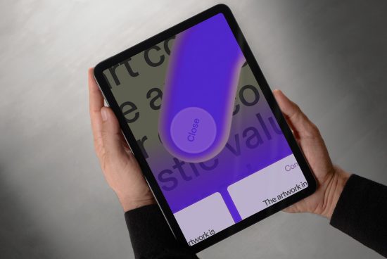 Hands holding a tablet displaying a digital design interface with bold fonts and a prominent close button ideal for UI mockups typography and graphics projects