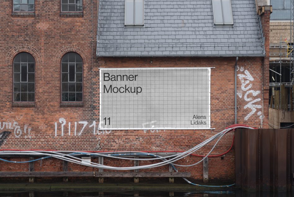 Urban wall banner mockup featuring a brick building with graffiti. Ideal for designers showcasing exterior advertising, templates, and graphic design presentations.